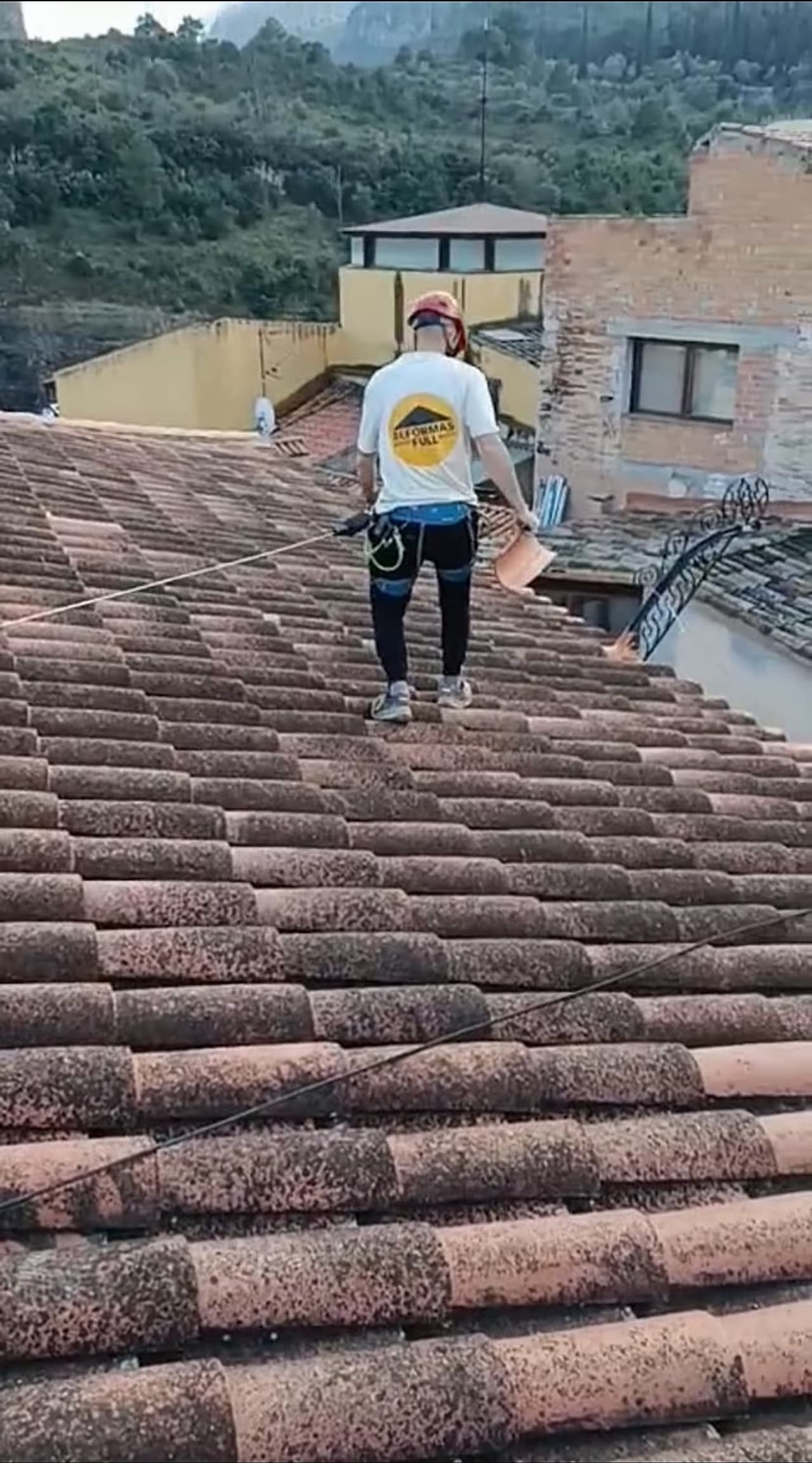 Operario asegurado durante un trabajo real sobre una cubierta
